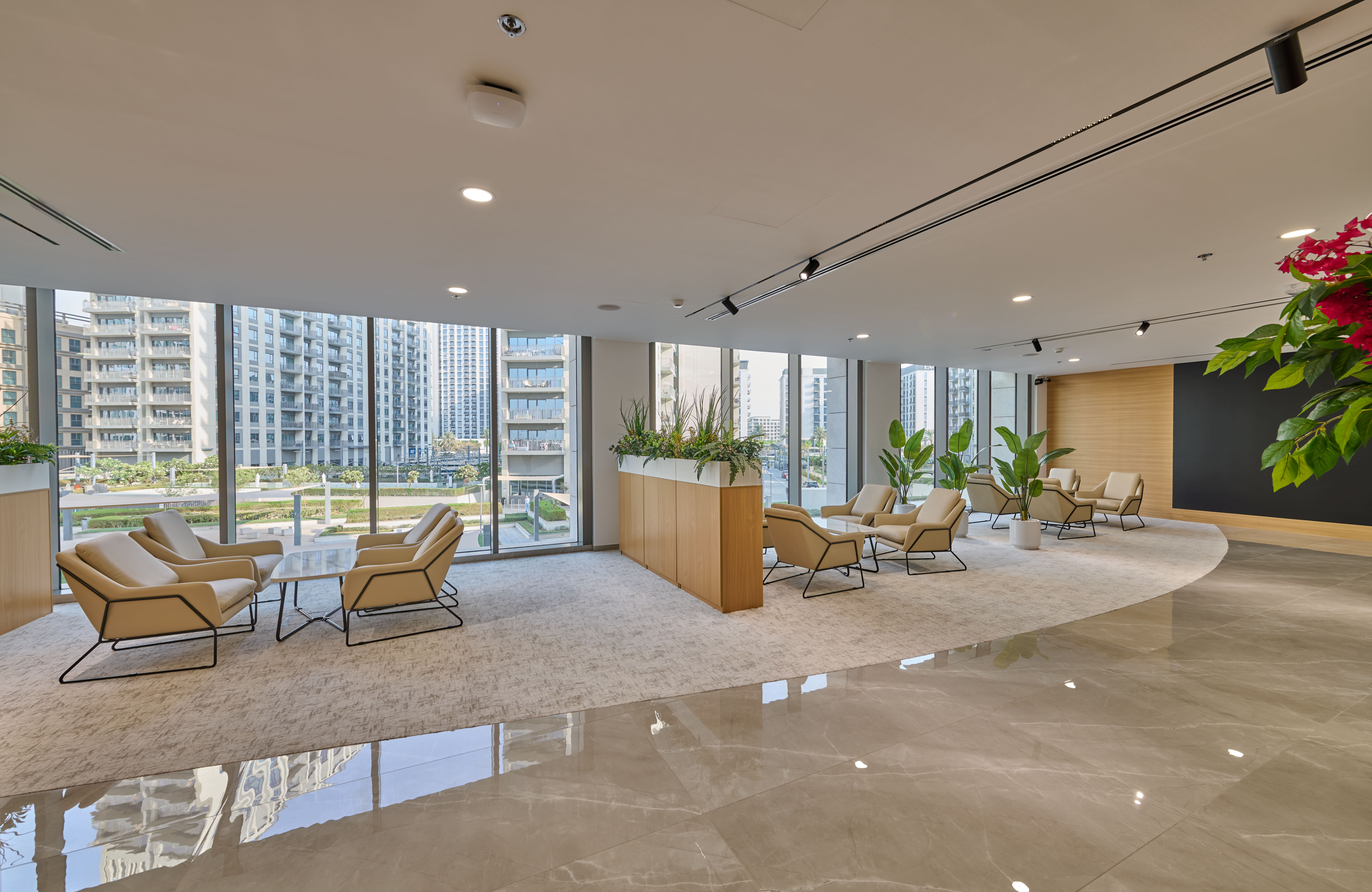 Modern office lounge featuring bespoke seating, elegant wood finishes, and premium Custom Office Furniture Dubai solutions with panoramic city views.